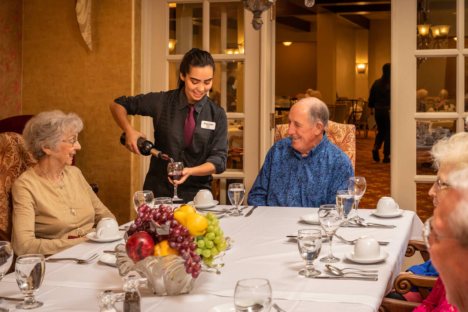 Server pouring wine at the dinner table